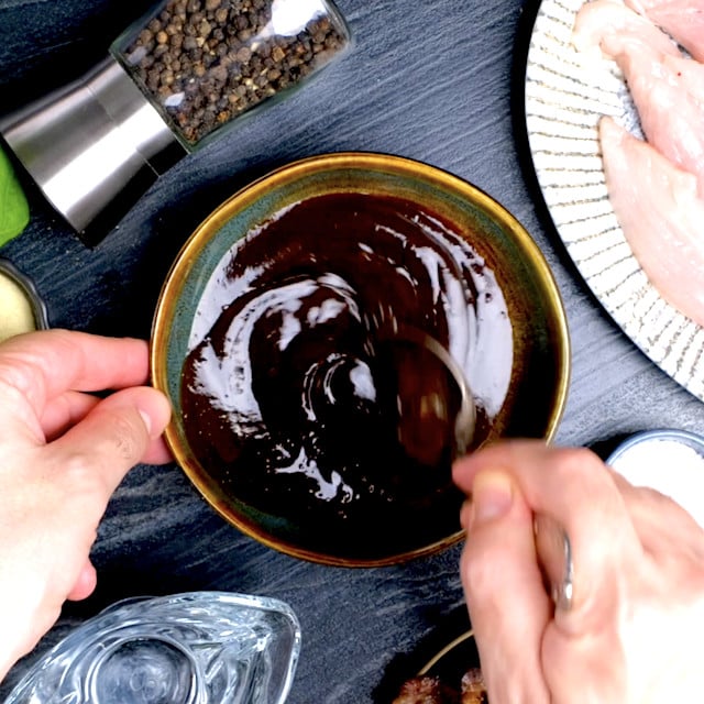 Sweet honey BBQ sauce being mixed with honey in a small bowl for BBQ chicken pizza recipe.