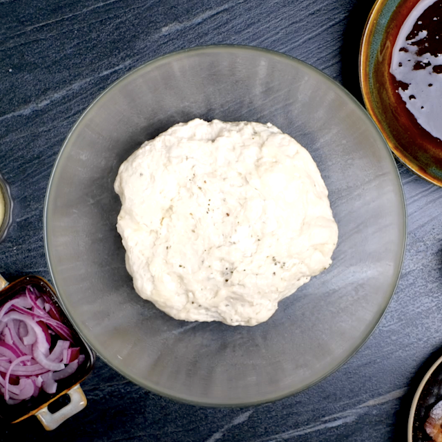 Pizza dough in a bowl, ready to rise to make BBQ chicken pizza.