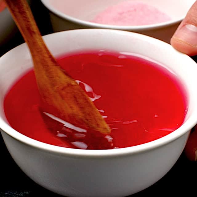 A bowl with jello mixture being stirred.