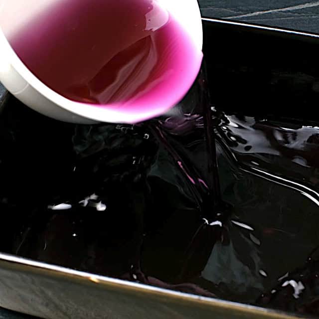 Jello mixture being poured in a pan to make rainbow jello.