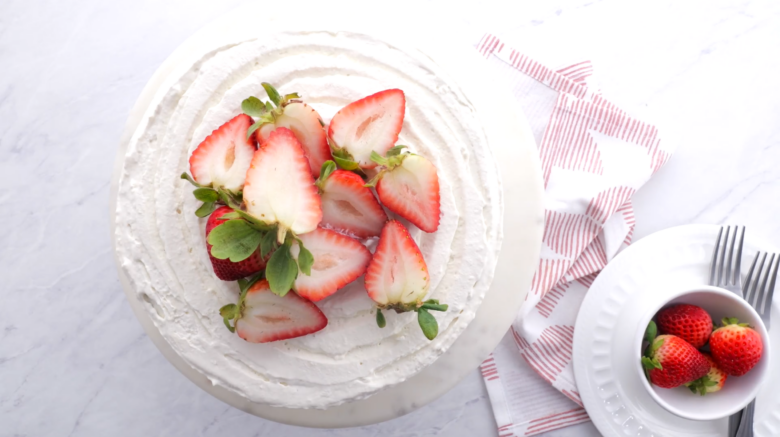 Chocolate strawberry cake assembled and topped with sliced strawberries.