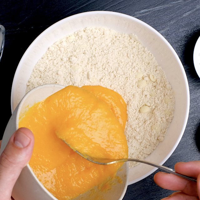 Pumpkin puree mixture being added to dry ingredients to make pumpkin scones.