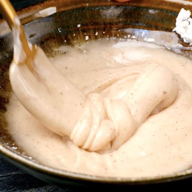 Spiced glaze being mixed in a bowl for pumpkin scones.