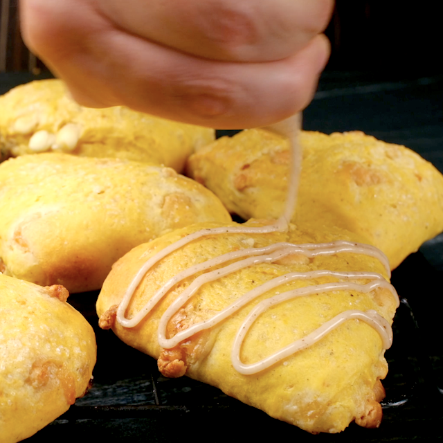 Spiced glaze being drizzled on top of freshly baked pumpkin scones.