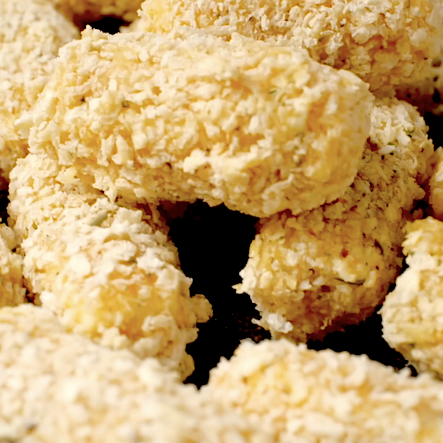 Mozzarella sticks coated in Panko breadcrumb mixture, ready to be fried.