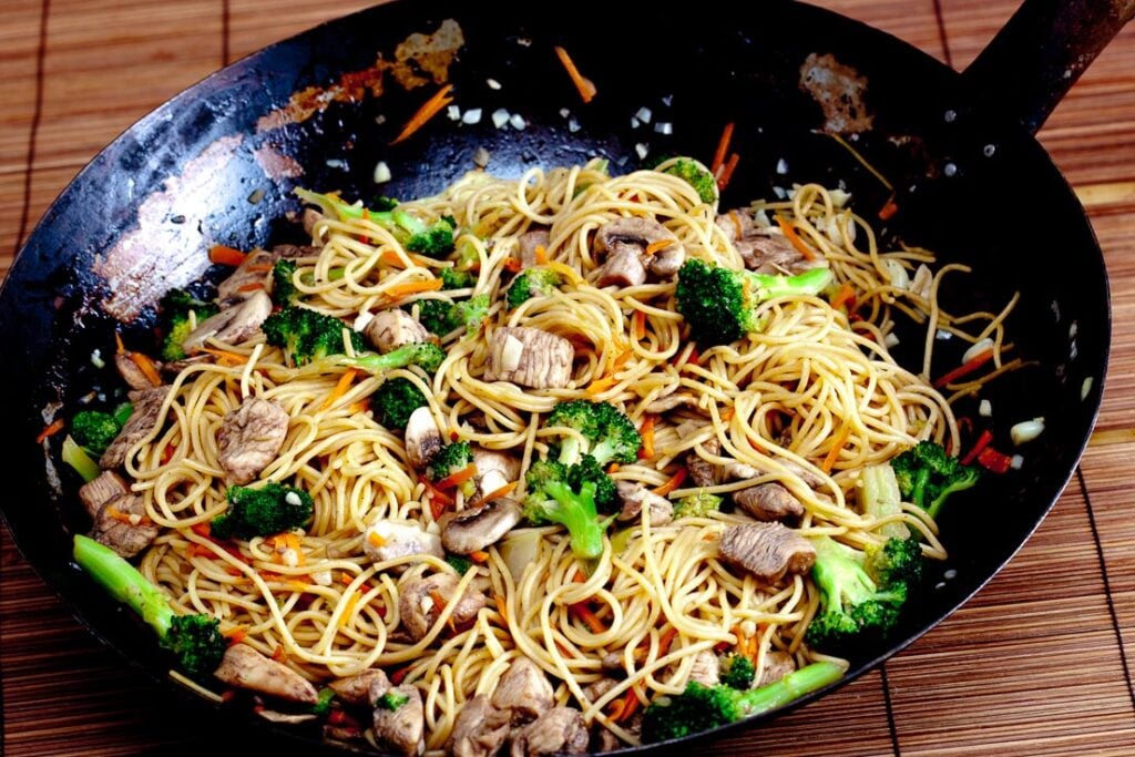 chicken chow mein with vegetables in a wok