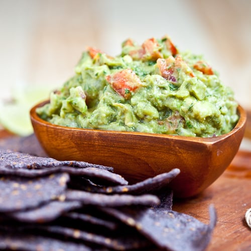 chunky guacamole in a bowl with chips