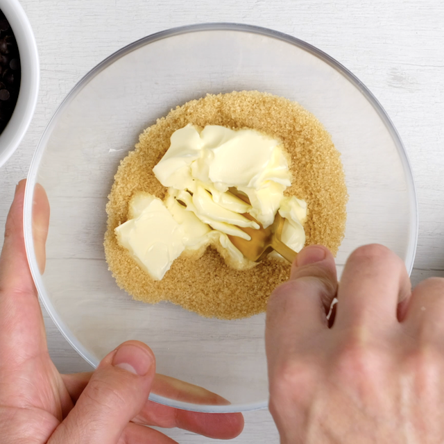 Brown sugar and butter being mixed together.