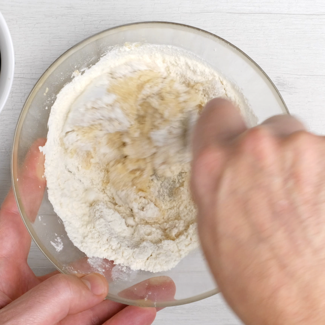 Flour being mixed into cookie dough topping mixture.