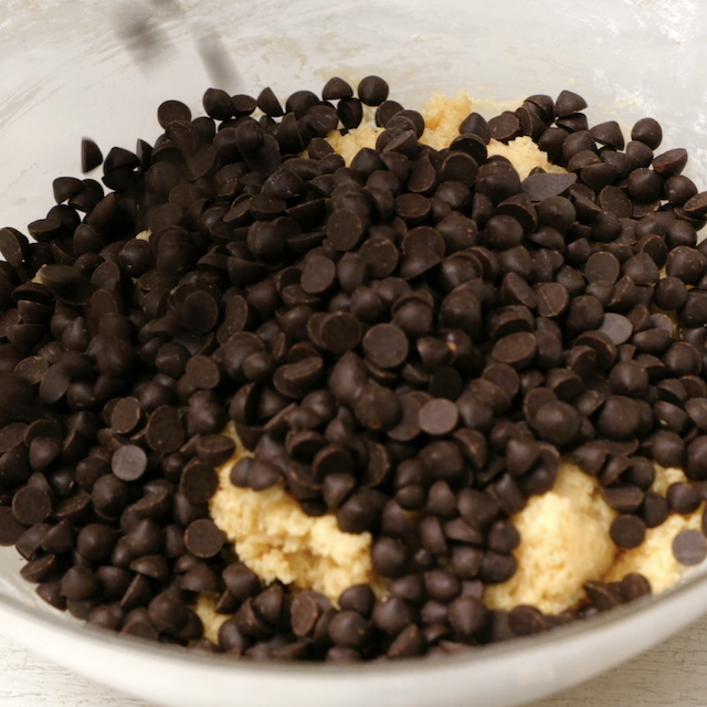 Mini chocolate chips being mixed into batter.