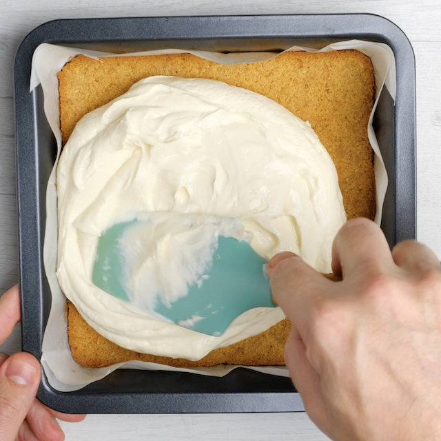 Cheesecake layer being spread to make chocolate chip cheesecake bars.