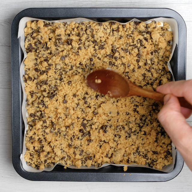 Cookie dough layer being pressed on.