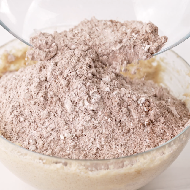 Dry ingredients being combined with wet ingredients to make peanut butter fudge cookies.