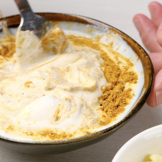 Curry dressing being whisked in a bowl to make chicken curry salad.
