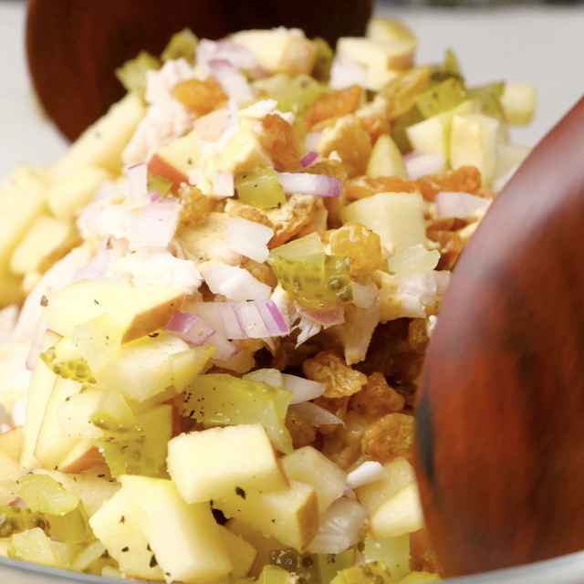 Chicken curry salad being tossed to being chilling and serving.