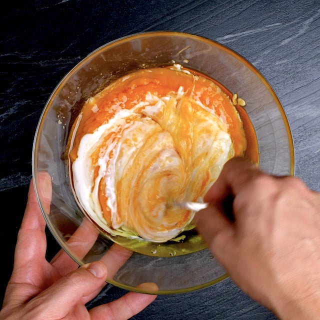 Wet ingredients to make pumpkin bundt cake with cream cheese frosting being mixed in a glass bowl.