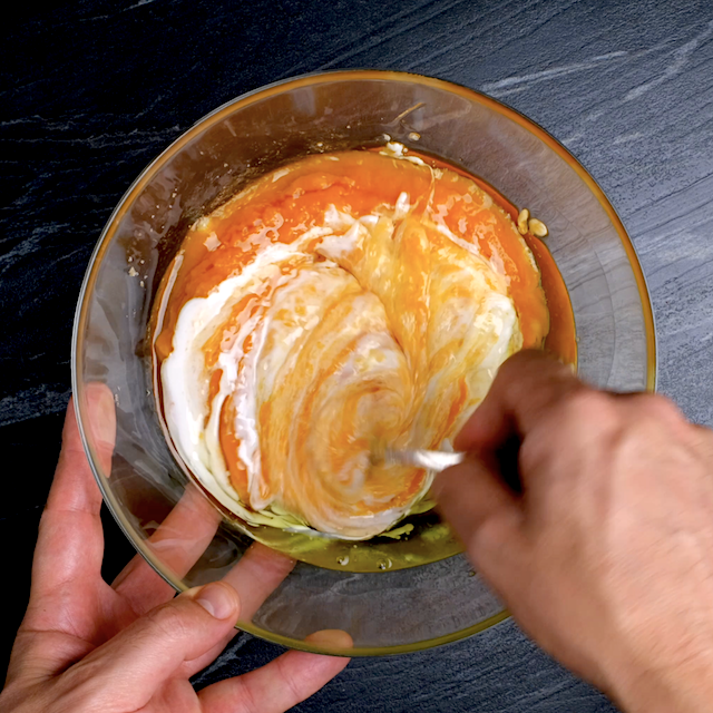 Wet ingredients to make pumpkin bundt cake with cream cheese frosting being mixed in a glass bowl.