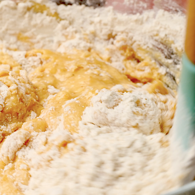Dry and wet ingredients to make pumpkin bundt cake being mixed together.