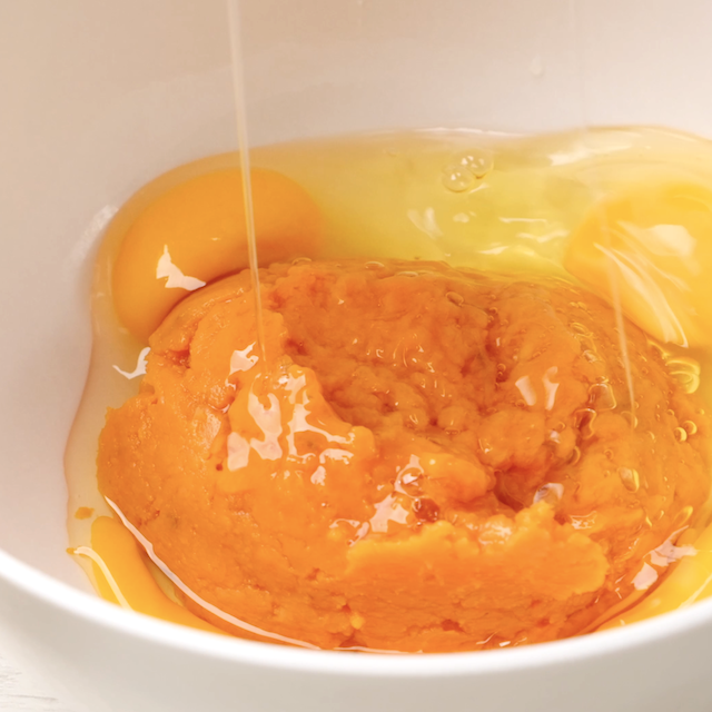 Eggs being added to mashed sweet potatoes.