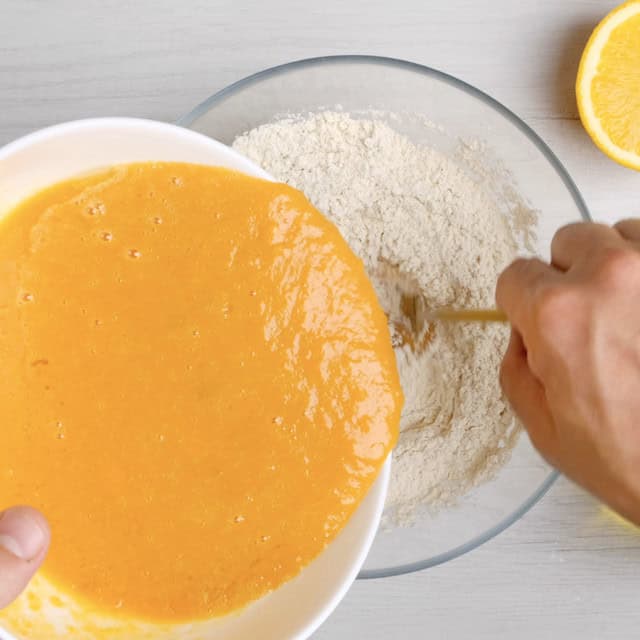 Wet ingredients to make sweet potato bread being mixed into dry mixture.