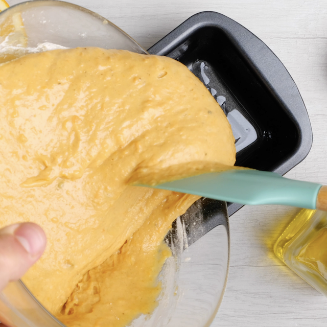Sweet potato bread batter being poured into greased pan.