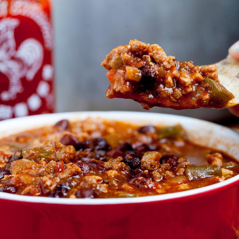 Chili being scooped up with a tortilla chip