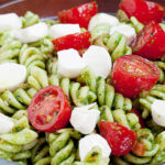 caprese pasta salad with tomatoes and mozzarella in a bowl