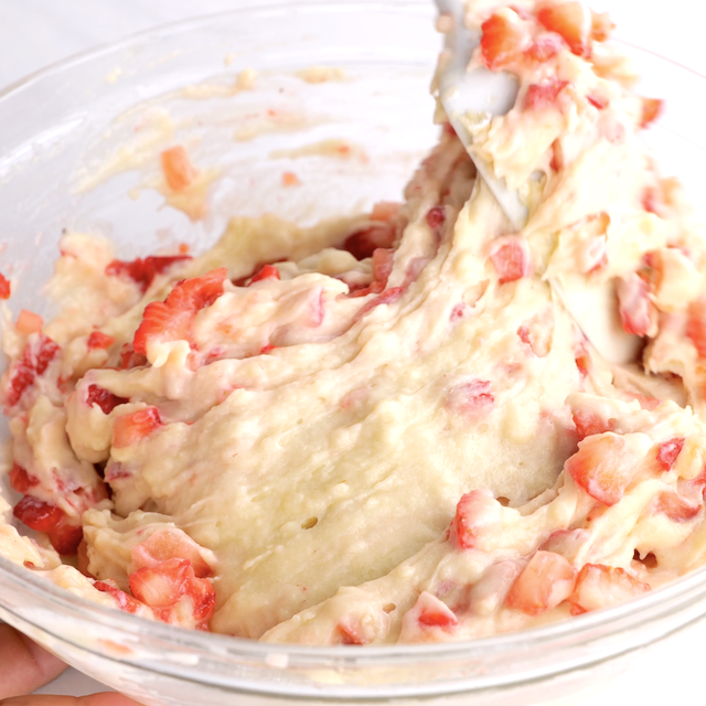 Chopped strawberries being folded into strawberry cupcake batter.