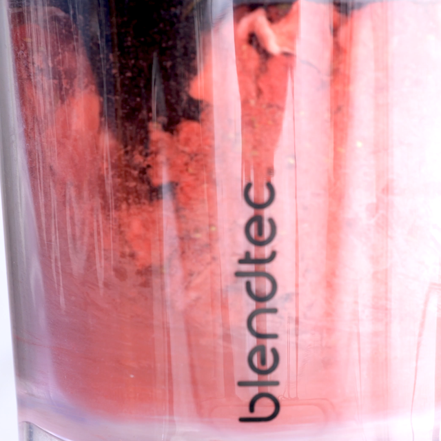Freeze-dried strawberries being blended into a fine powder to make strawberry whipped cream frosting.