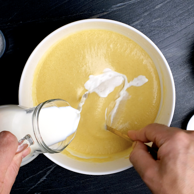 Butter, sugar, egg, and milk mixture being mixed by hand to make brown sugar pound cake.