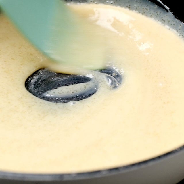 Caramel drizzle being made in a pan using condensed milk and brown sugar.
