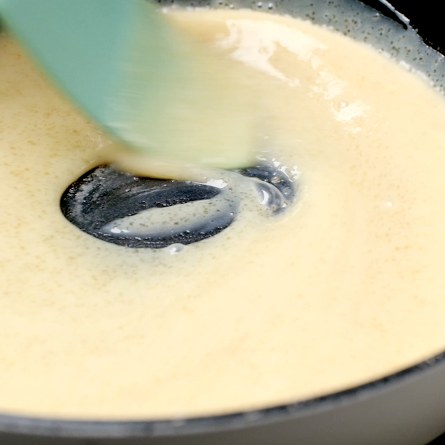 Caramel drizzle being made in a pan using condensed milk and brown sugar.