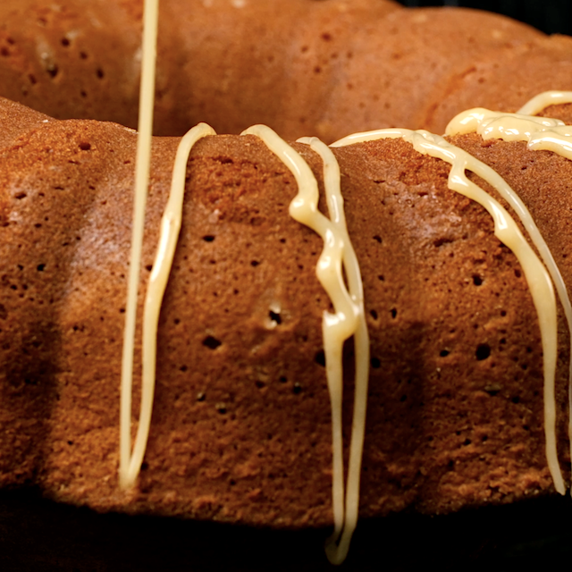 Homemade caramel being drizzled on brown sugar pound cake before serving.