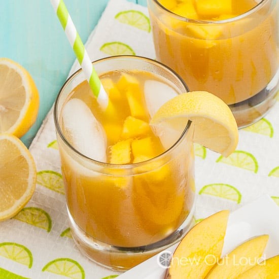 mango cooler cocktails in glasses with slices of mango and lemons