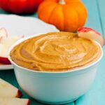 Pumpkin cream cheese dip in a bowl with apple slices.