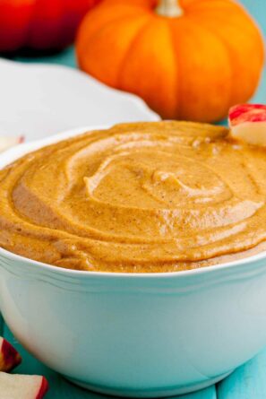 Pumpkin cream cheese dip in a bowl with apple slices.