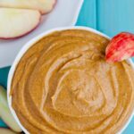 Pumpkin cream cheese dip in a bowl with apple slices.