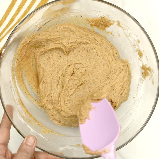 Dry ingredients being folded into wet ingredients to make pumpkin cookies at home.