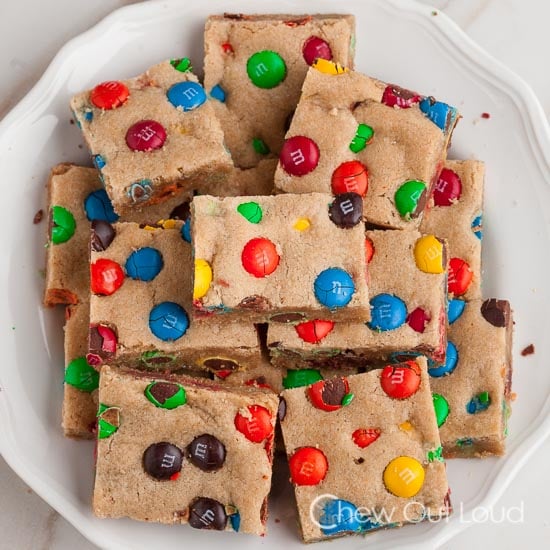 M&M cookie bars cut up in squares on a plate