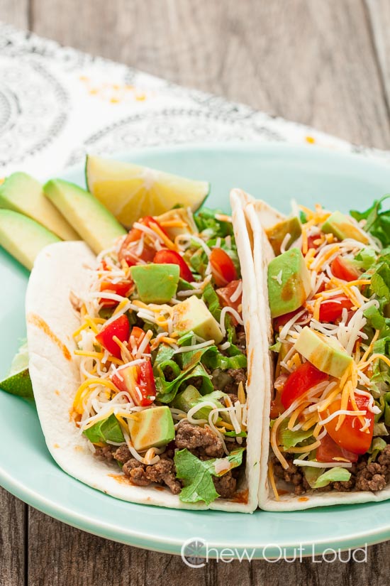 A plate of Homemade Tacos with Sliced Avocado and Tomato