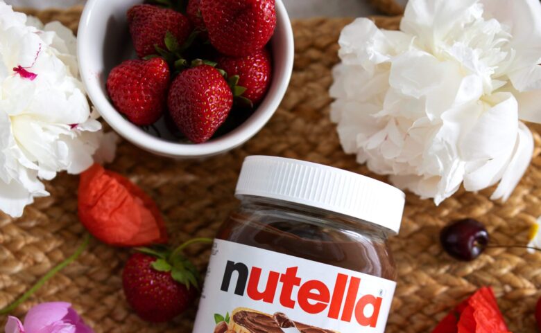 Jar of Nutella and fresh strawberries.