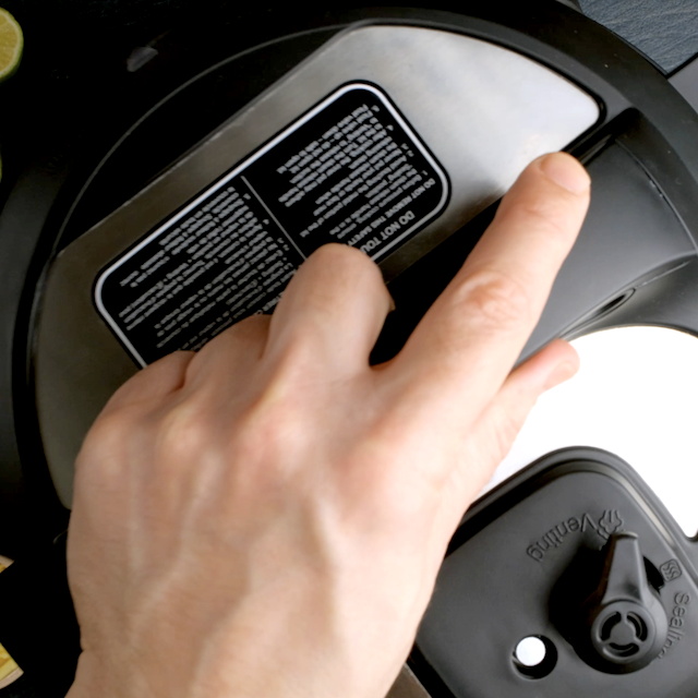 A person closing the lid of a crockpot to make crockpot salsa chicken at home.