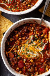 lentil chili in bowl with cheese and tortilla chips