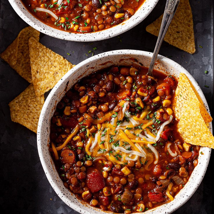 lentil chili in bowl with cheese and tortilla chips