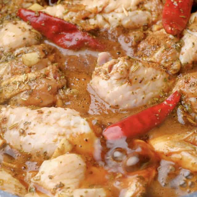 Closeup shot of wing chickens being braised in a pot to make Asian chicken wings at home.