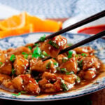 orange chicken with chopsticks