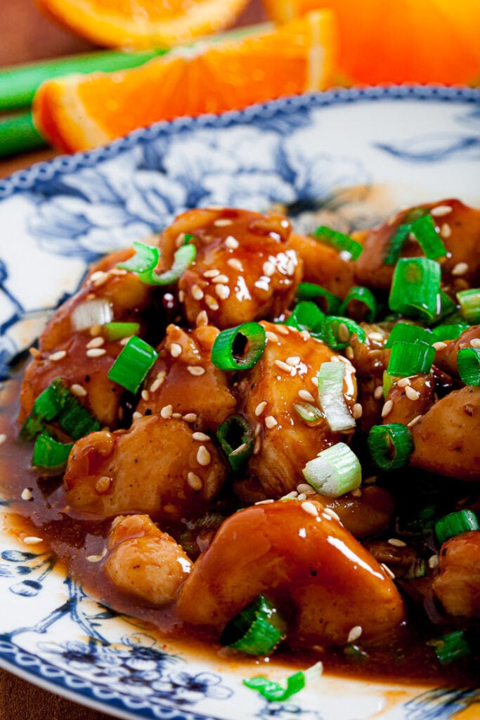 orange chicken on a plate with orange slices