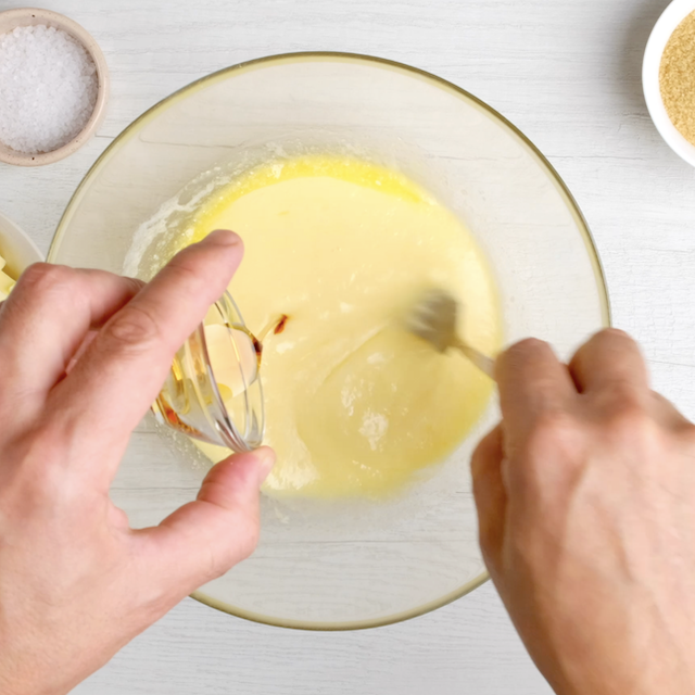 Wet ingredients to make apple coffee cake recipe being mixed in a glass bowl.