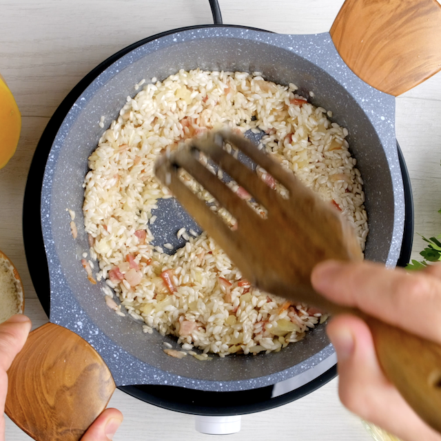Arborio rice being cooked in a pot to make butternut squash risotto.