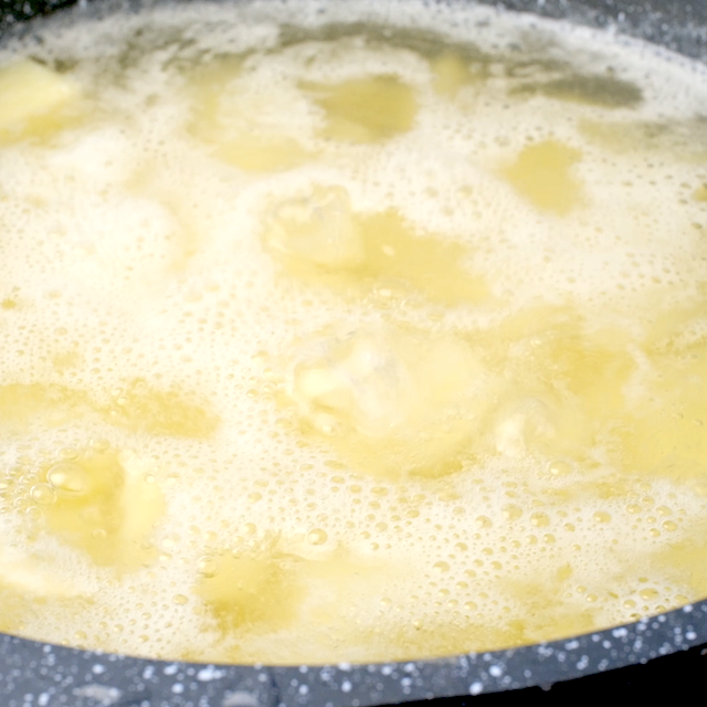 Potatoes being boiled in a pot of hot water.